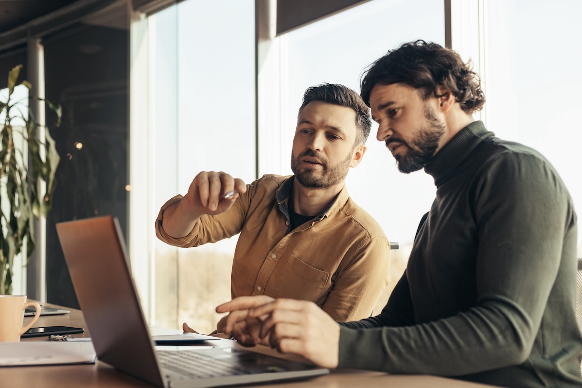 executives reviewing disability insurance policy comparison and income protection strategy on a laptop, evaluating own occupation coverage, benefit period options, elimination period terms, and supplemental disability insurance designed to protect executive income, bonuses, and deferred compensation