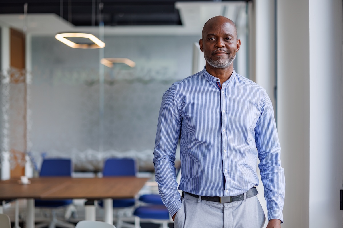 Practice owner standing in modern office, the independent business owner who buys business overhead expense disability insurance from Guardian, Principal Financial Group, MassMutual, or The Standard to fund rent and payroll during a covered disability period