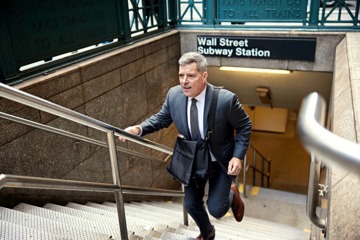 Financial services executive rushing up the stairs from the Wall Street subway station.