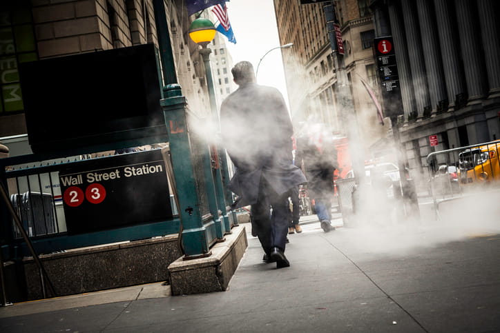 A securities broker walking near the Wall Street Station subway entrance in New York's Financial District